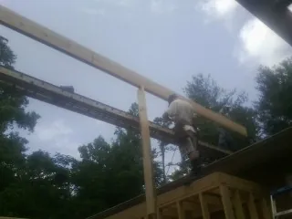 Carpenter setting a ridge beam over a new addition frame — Ice Dam Removal by Roofing Brothers in Laramie