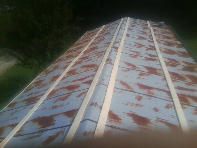 Rusted metal roof panels with new wood purlins before replacement — Storm Damage Roof Repair in Laramie by Roofing Brothers