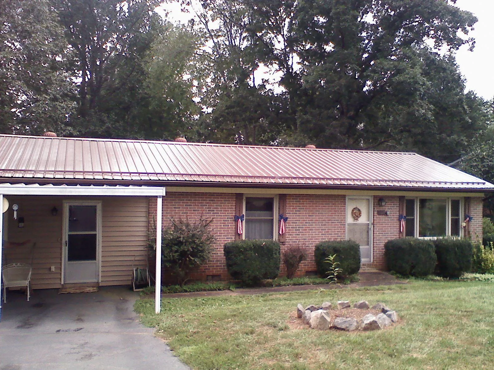 Bronze metal roof and carport on a brick ranch home — Roof Repair work by our crew in Laramie