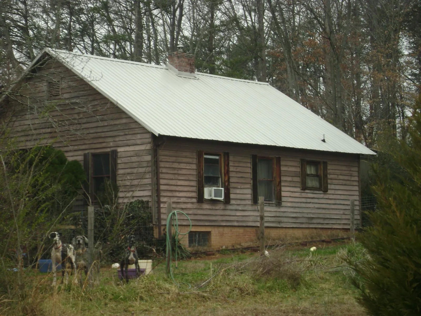 White metal roof on an old wood sided farmhouse, from a Metal Roof Installation job in Laramie